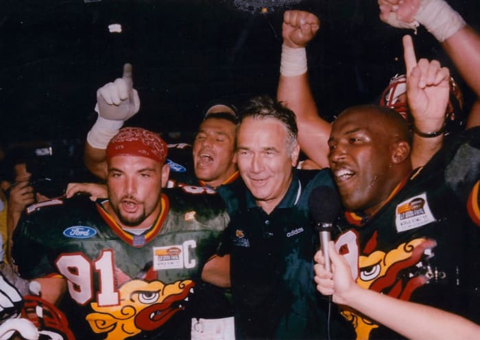 Naposki celebrates with Barcelona Dragons coach Jack Bicknell (center) and other teammates after their 1997 World Bowl victory.